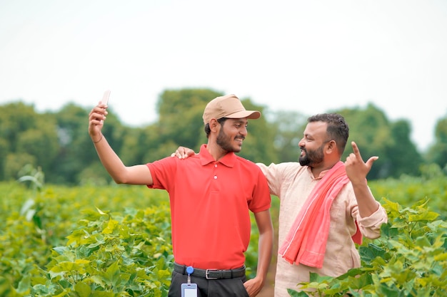 Agrônomo indiano ou oficial com fazendeiro no campo de agricultura.