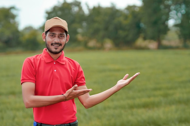 Agrónomo indio dando expresión con la mano en el campo de la agricultura.