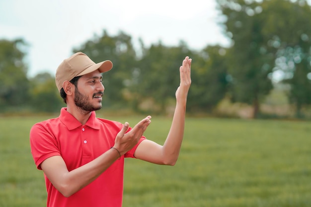 Agrónomo indio dando expresión con la mano en el campo de la agricultura.