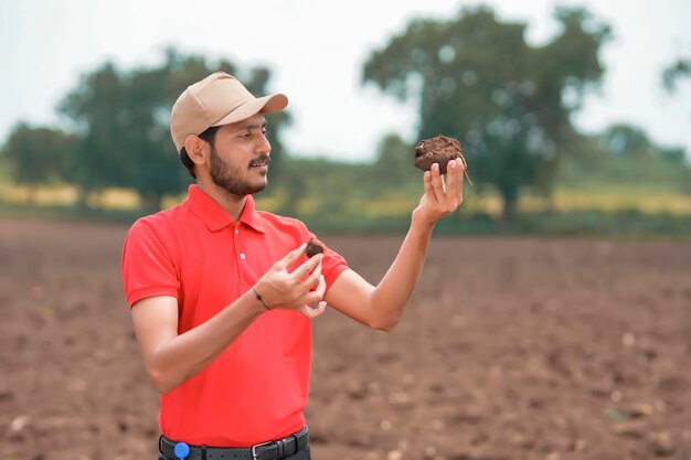 Agrónomo indio probando el suelo en el campo agrícola.