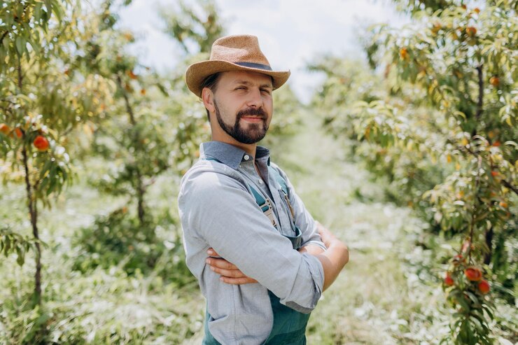 Agrónomo de pie en el jardín de melocotón