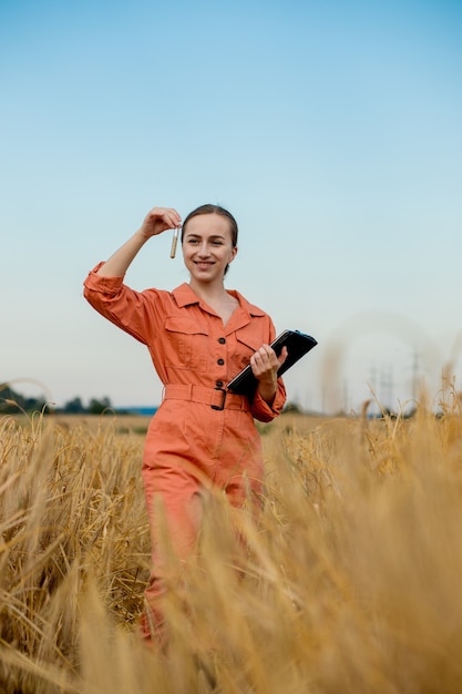 Agrónomo sosteniendo el tubo de ensayo con granos de cebada en el campo, primer plano. Cultivo de cereales, a excepción de las pruebas de trigo