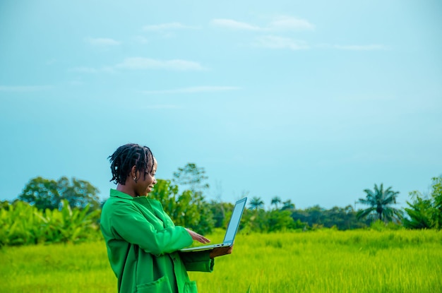 Agrônomo usando laptop na fazenda e sorrindo