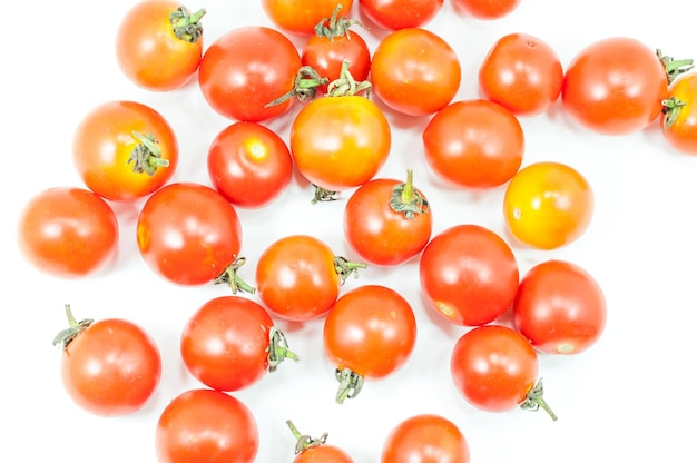 Agrupación de tomates cereza maduros sobre un fondo blanco