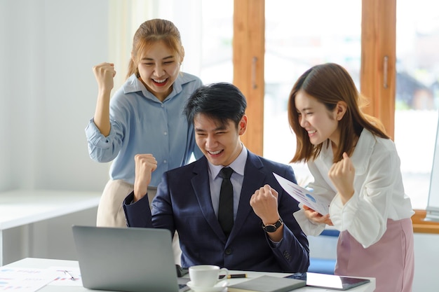 Agrupe jovens empresários asiáticos com as mãos levantadas animadas e criativas, regozijando-se com o novo conceito de projeto de inicialização