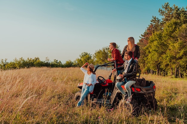 Agrupe jovens felizes desfrutando de um lindo dia ensolarado enquanto dirige um carro de buggy off road na natureza montanhosa.