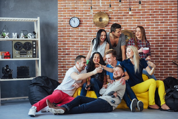 Agrupe o retrato de meninos e meninas multiétnicas com roupas da moda coloridas, segurando o amigo posando em uma parede de tijolos, pessoas de estilo urbano se divertindo, s sobre estilo de vida de juventude união