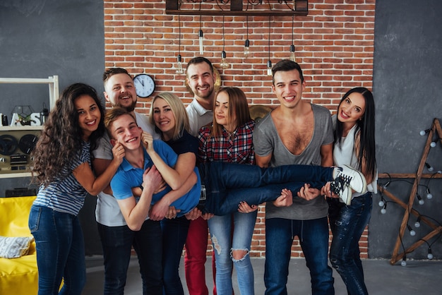 Agrupe o retrato de meninos e meninas multiétnicas com roupas da moda coloridas, segurando o amigo posando em uma parede de tijolos, pessoas de estilo urbano se divertindo, s sobre estilo de vida de juventude União