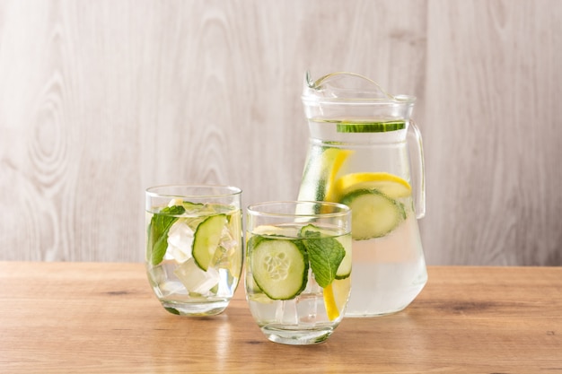 Água atrevida ou água com pepino e limão na mesa de madeira