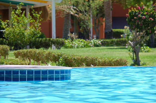 Agua azul clara con pequeñas olas onduladas en la piscina del resort tropical. Concepto de vacaciones de verano.