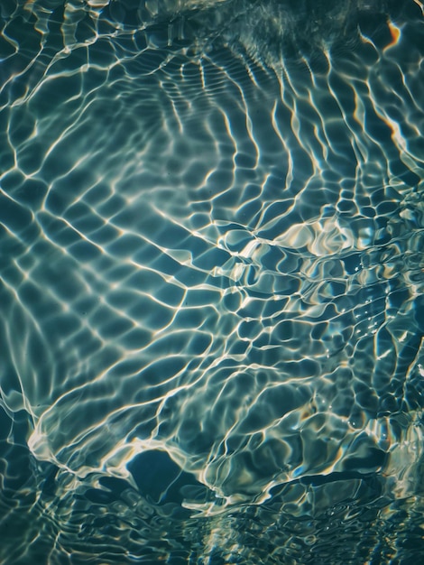 Foto un agua azul con ondas y el sol reflejándose en ella