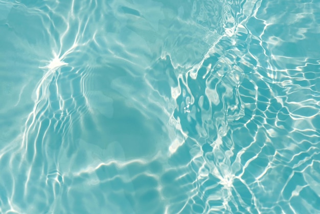 Un agua azul en una piscina con el sol brillando sobre ella.