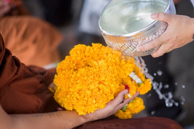 Agua en la bañera de agua con flores coloridas pedestal para el festival de Songkran Tailandia