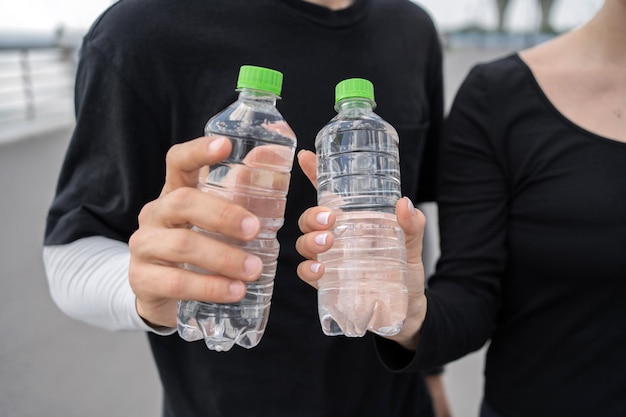 El agua se bebe de botellas de plástico fitness hombre y mujer