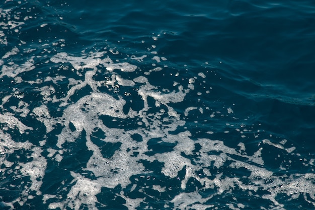 Agua burbujeante y espuma de mar del motor del barco, el concepto de movimiento del agua, color grava del mar.