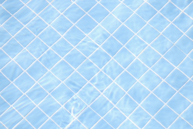 Agua clara transparente en la piscina sobre fondo de azulejos azules