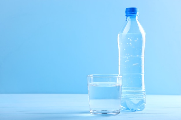 Agua clara en un vaso y una botella sobre la mesa.