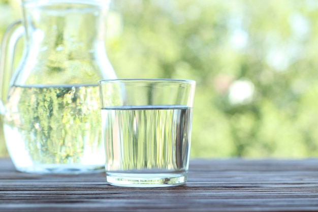 Agua clara en un vaso sobre una mesa de agua purificada de la naturaleza