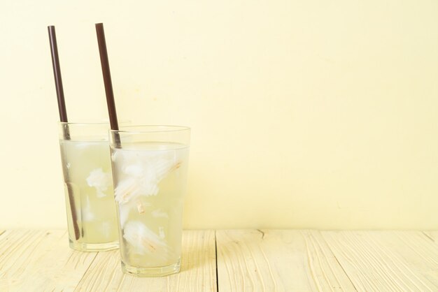 agua de coco o jugo de coco en glas con cubito de hielo