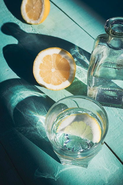 Foto Água com limão em um fundo de madeira turquesa bebida com bebida de desintoxicação de vitamina c