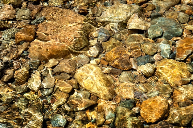 Água cristalina no rio e textura de pedra