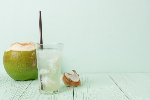 água de coco ou suco de coco em copo com cubo de gelo