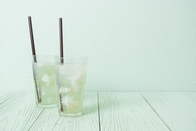 água de coco ou suco de coco em copo com cubo de gelo