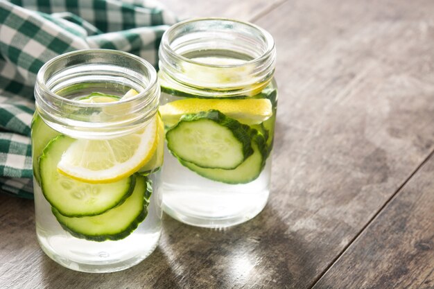 Agua de desintoxicación con pepino y limón en el espacio de copia de mesa de madera