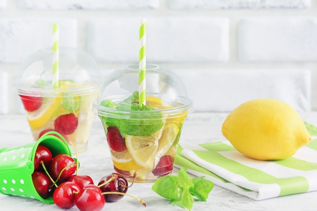 Foto agua de desintoxicación con rodaja de limón, bayas y hojas de menta