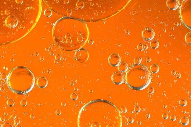 Foto Água em óleo em estilo abstrato em fundo amarelo respingo de líquido laranja óleo de bolha amarelo dourado