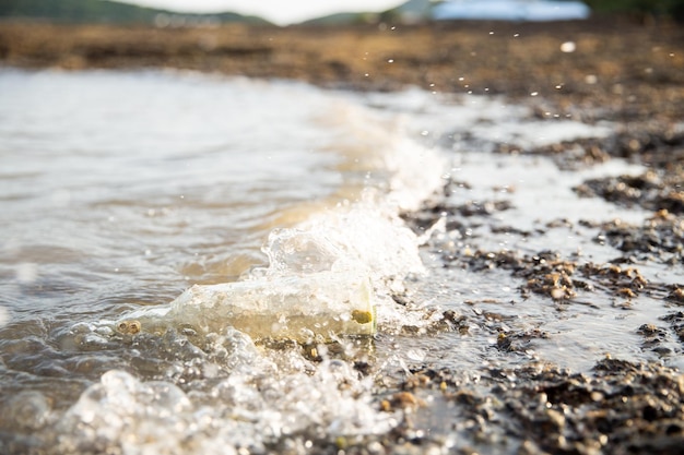 Foto agua embotellada arrastrada por desechos marinos de agua de mar