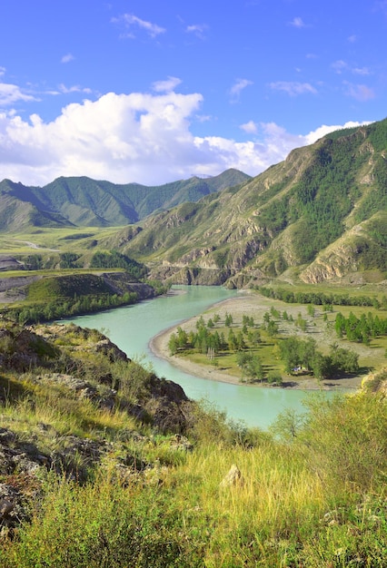 Agua esmeralda en la curva de un río de montaña entre las montañas rocosas bajo un cielo azul Siberia