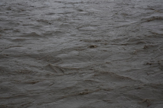 El agua fangosa sucia fluye en el río después de que la nieve se derrita, temprano