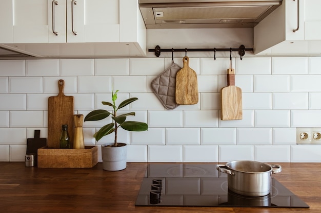 Água fervendo em uma panela e uma panela em um fogão de indução na cozinha branca moderna