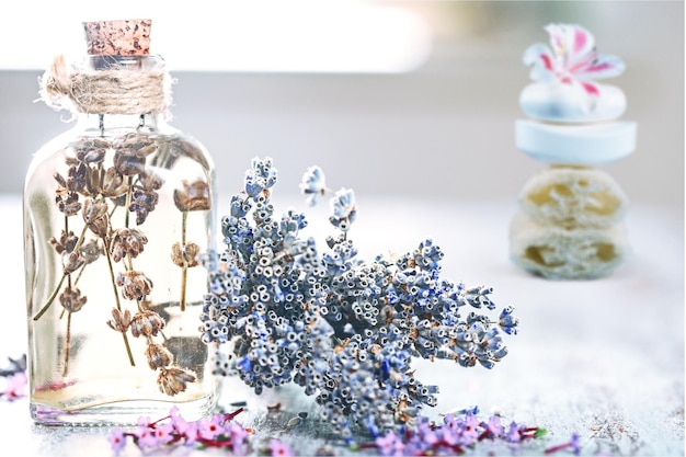 Agua de flor de hierba de lavanda en una botella de vidrio con flores