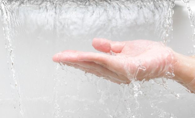 El agua fluye por la mano de la mujer