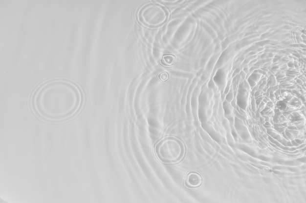 Agua de fondo ondulación tranquila textura de agua círculos y burbujas sobre una superficie blanca líquida c