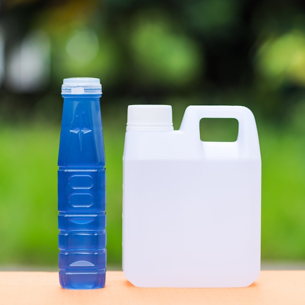 Agua fresca en contenedor en la mesa con fondo de desenfoque de la naturaleza, agua dulce para beber