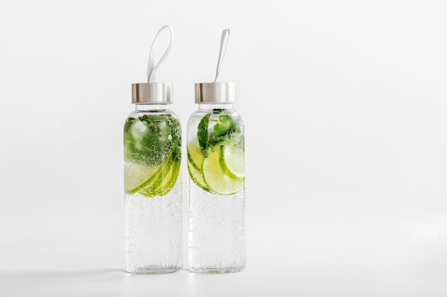 Agua fresca con infusión de limón y menta, cóctel, bebida desintoxicante, limonada en botellas reutilizables. Bebidas de verano. Concepto de salud.