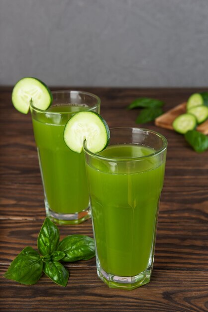 Agua fresca de pepino con albahaca y limón en vasos sobre mesa de madera