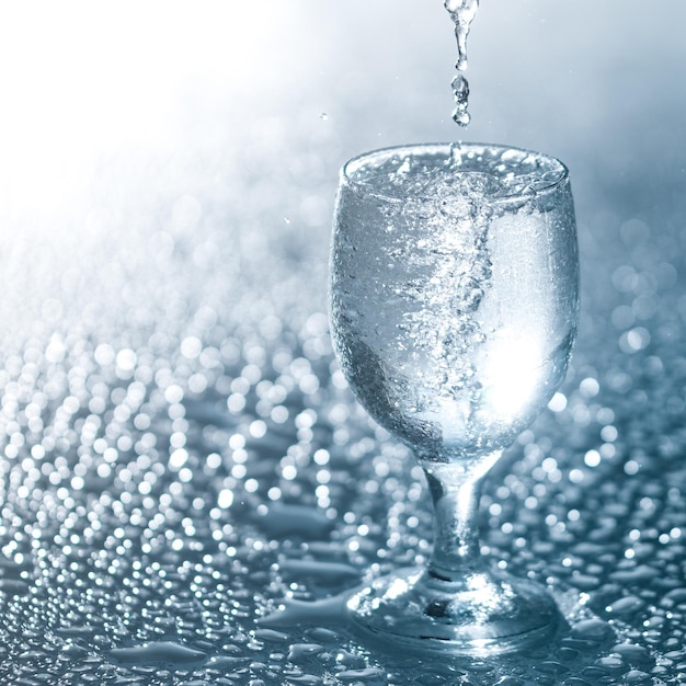 Un agua fría clara y fresca se vierte en un vaso