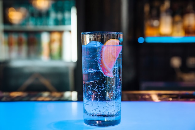 Agua fría en un sakan transparente con hielo con limón.