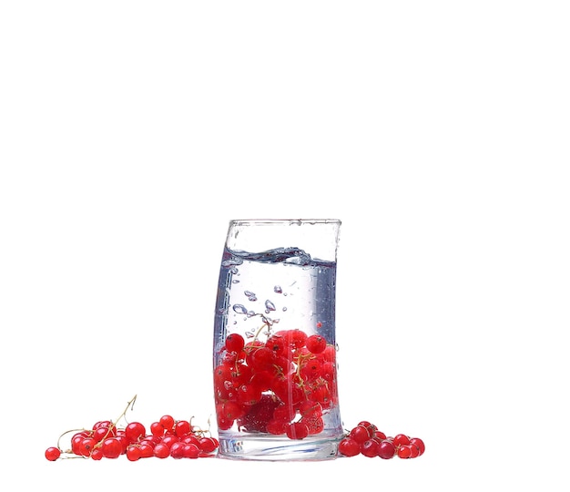 Agua con grosellas rojas aislado en blanco
