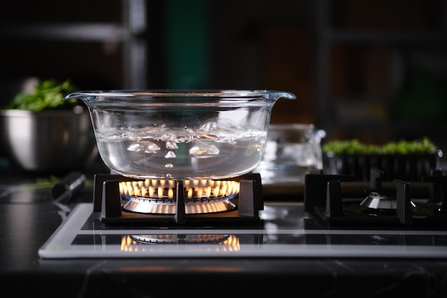 Foto agua hirviendo en una olla transparente en una estufa de gas