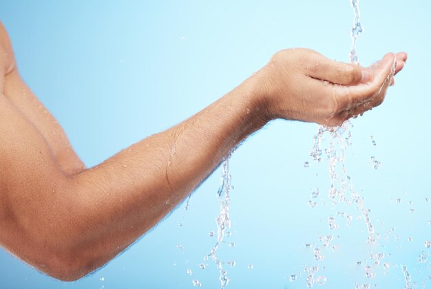 Agua de hombre o lavado de manos sobre fondo azul para el mantenimiento de la higiene corporal bienestar de la salud o rutina de cuidado de la piel Modelo de salpicadura de agua o ducha corriente para limpiar bacterias o autocuidado