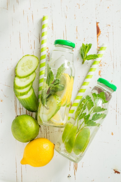 Agua infundida con cítricos y hierbas en botella de vidrio.