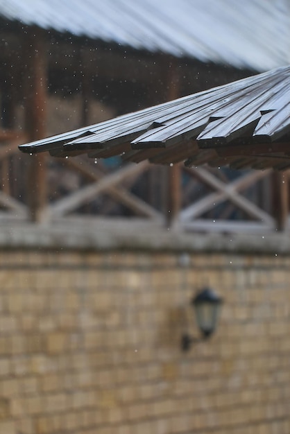 El agua de lluvia gotea desde un techo de madera