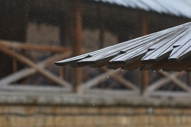 El agua de lluvia gotea de un techo de maderaxA