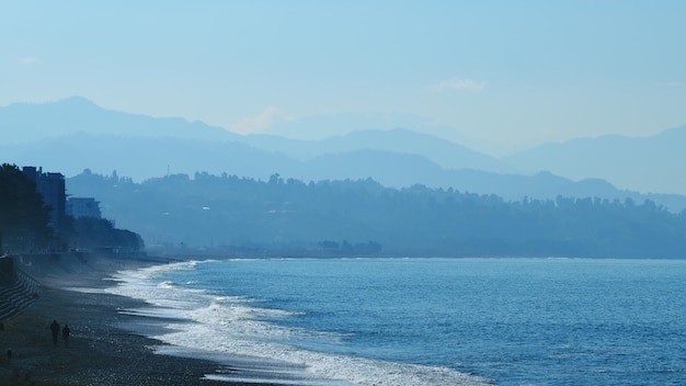 Agua de mar azul con la lejana costa montañosa en el horizonte en tiempo real