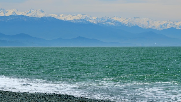 Foto agua de mar azul con la lejana costa montañosa en el horizonte en tiempo real